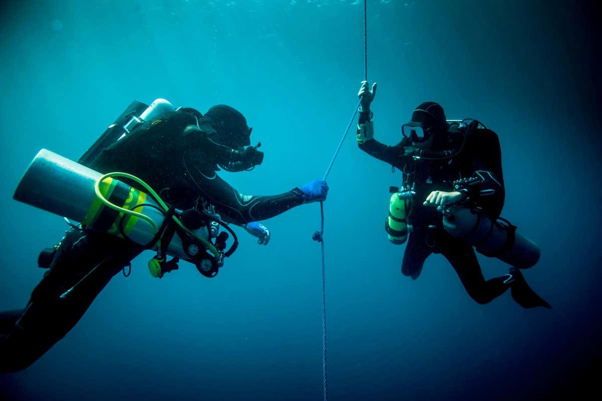 F3HB7N Underwater view of two technical divers using rebreathers device to locate shipwreck, Lombok, Indonesia