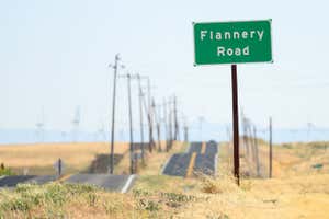 A road sign is posted near a parcel of land recently purchased by Flannery Associates near Rio Vista, California on September 15, 2023. A stealth campaign by Silicon Valley elites with a dream of turning a swath of California farmland into a new age city has ranchers who live here challenging their tactics as well as their motives. The project first surfaced when a mysterious buyer started gobbling up parcels of land in this rural outback between San Francisco and Sacramento. The buyer, first revealed by the New York Times in August, turned out to be a secretive outfit called Flannery Associates. (Photo by JOSH EDELSON / AFP) (Photo by JOSH EDELSON/AFP via Getty Images)